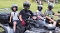 Zwei Kinder und zwei Erwachsene mit Helmen sitzen auf zwei Quads auf einer Wiese bei einem Sommerfest für Kinder und Familien