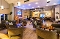 Gemütlich eingerichtete Hotelbar Salt&Sun mit mehreren Tischen und Sesseln, warmen Holzakzenten und indirekter Beleuchtung
