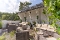 Terrasse mit Rattanmöbeln, mehreren Sofas und Sesseln, Holzboden und weißen Wänden unter einem schrägen Dach