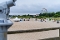 Strand mit vielen Strandkörben, im Vordergrund ein Fernglas und im Hintergrund ein Riesenrad und Gebäude