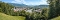 Panoramablick auf Bad Tölz mit Fluss, umgeben von bewaldeten Hügeln und Bergen im Hintergrund