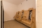 Drei an der Wand montierte Holzsitze mit Rückenlehnen und integrierten Infrarotstrahlern in einem hellen Raum